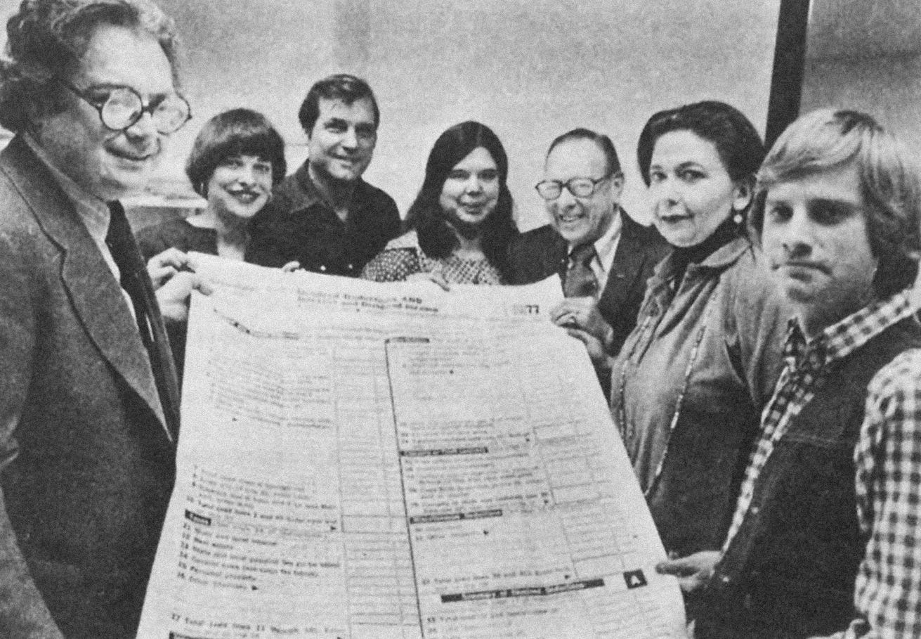 Gathered around a giant 1040 Form at Equity's VITA program office
